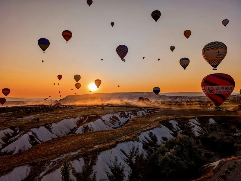 Panoramic sunrise view of hot air balloons over Cappadocia