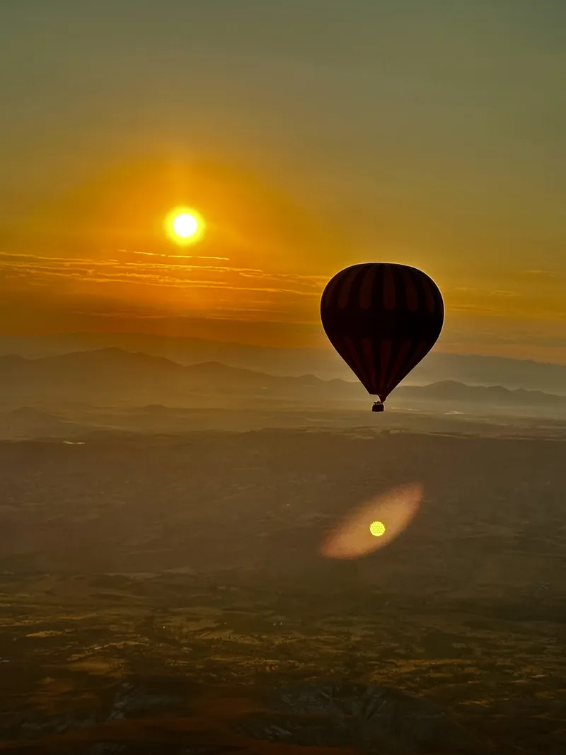 La silueta de un solo globo aerostático contra el amanecer de Capadocia